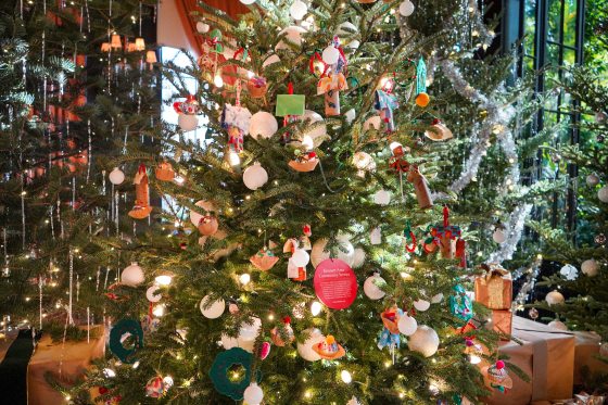 A Christmas tree decorated with ornaments made by young children.
